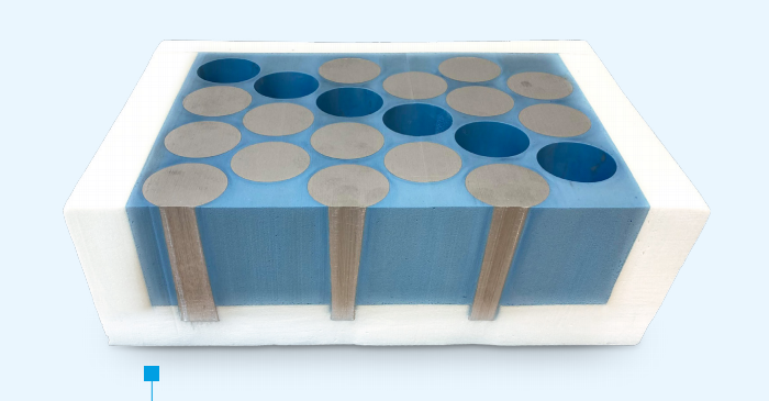 Illustration of cylindrical battery cells embedded in a blue encapsulation block, shown in cross-section