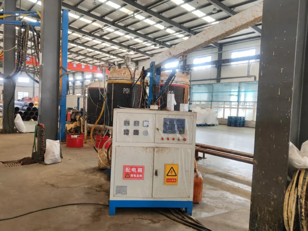 Control cabinet and material tanks of pipe-insulation foaming equipment in a Liaoning workshop.