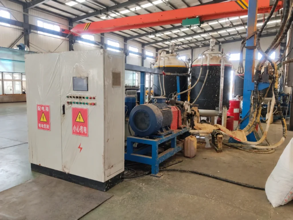 Side view of a control cabinet, metering drive and material tanks at a Liaoning pipe-insulation equipment site.