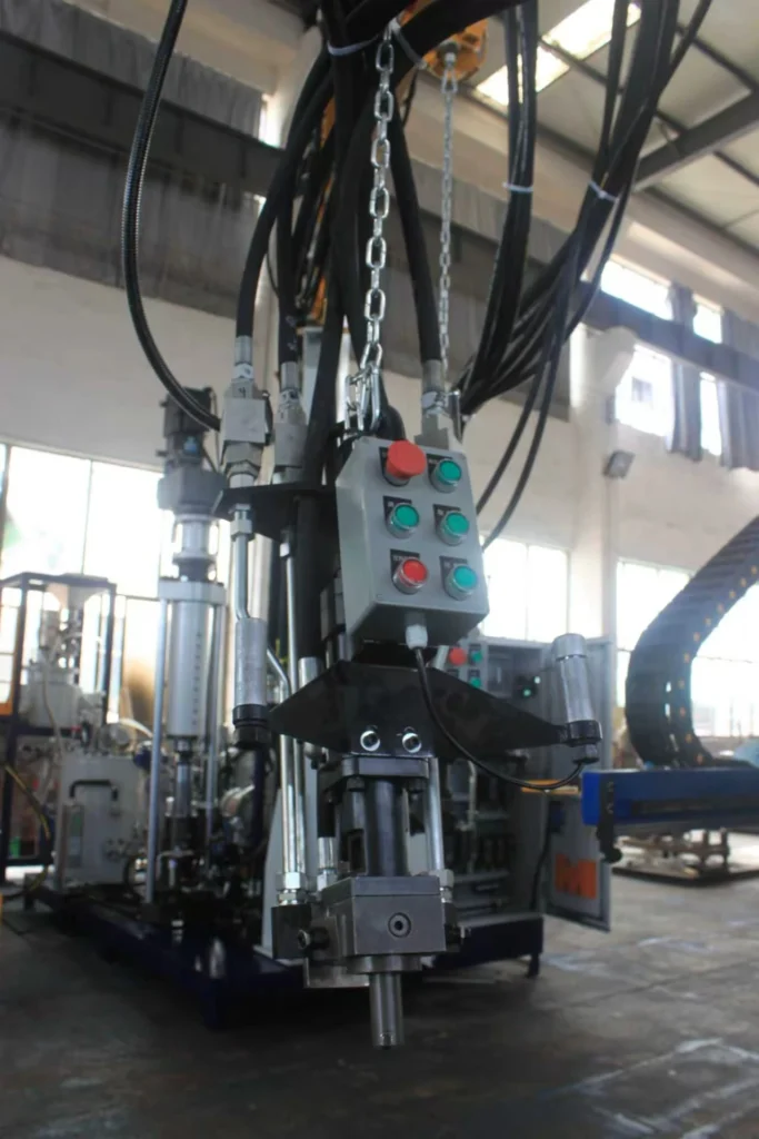 Suspended polyurethane mixing head with control buttons in an equipment workshop